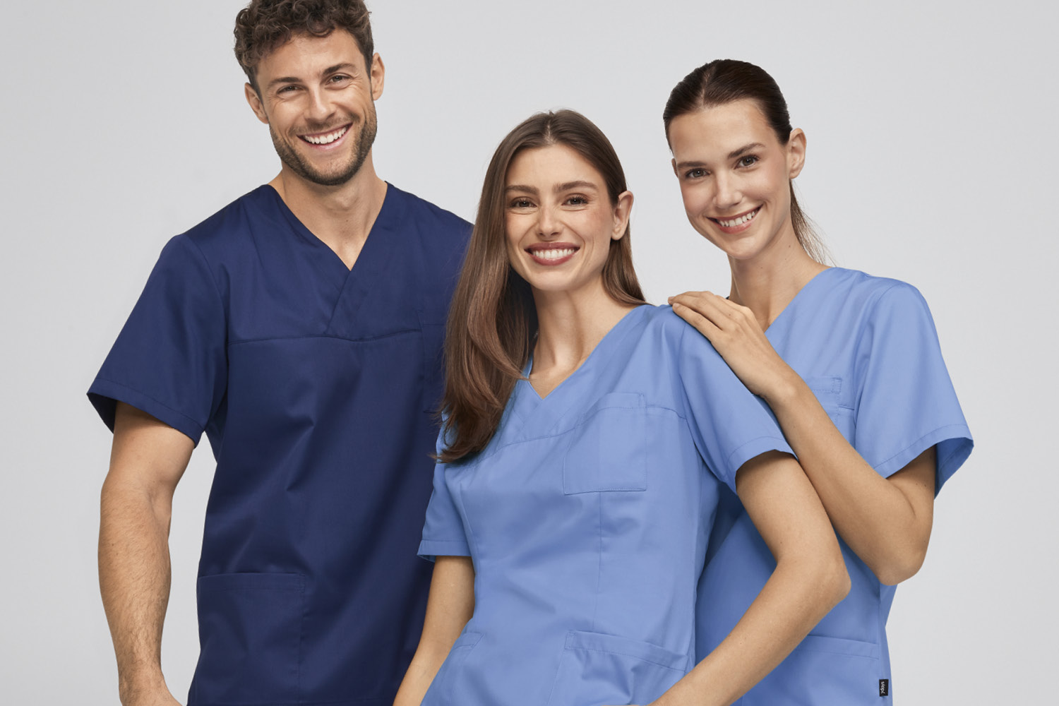 Drie personen in 7days-werkkleding kijken in de camera